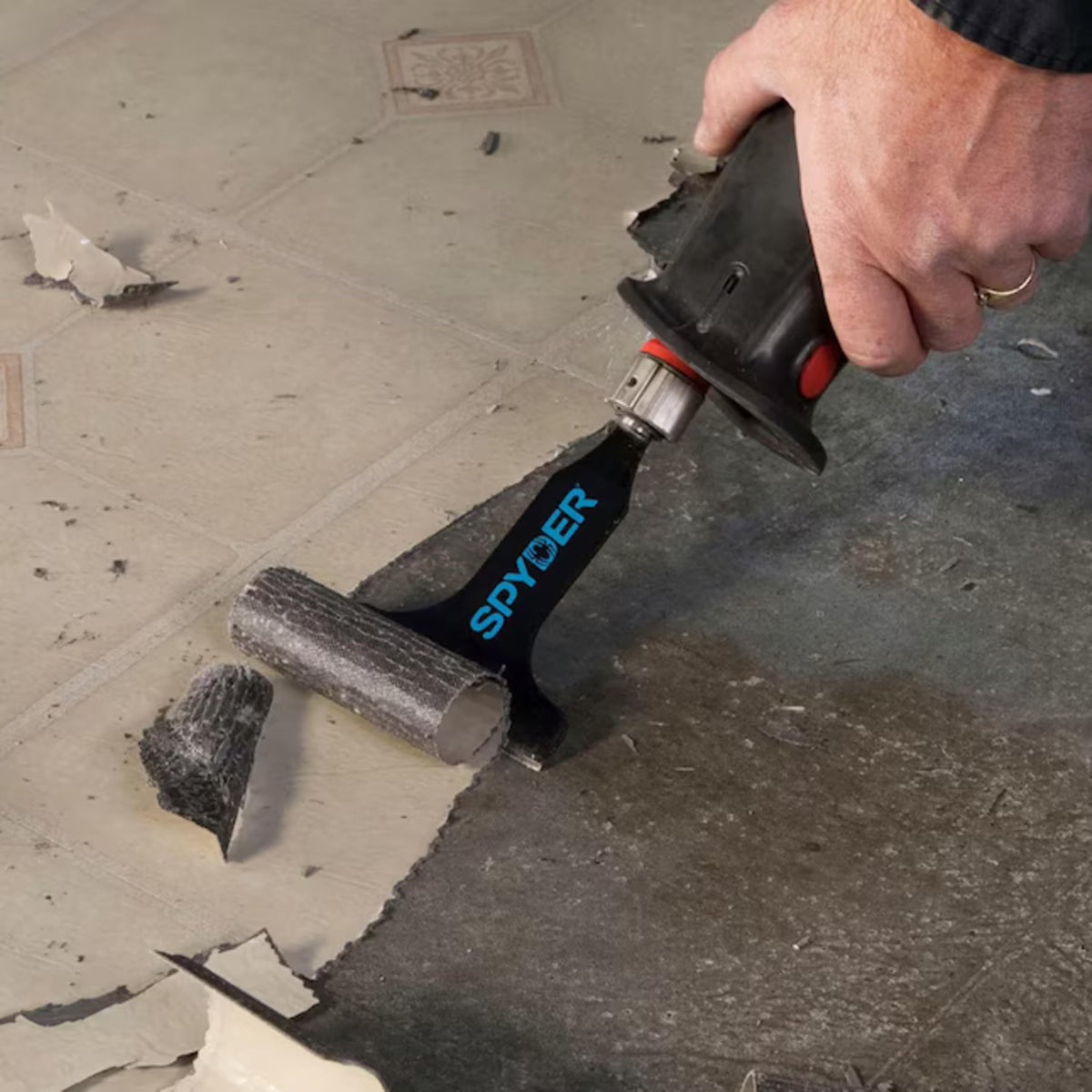 Spyder scraper in use removing tile, demonstrating efficient material removal.