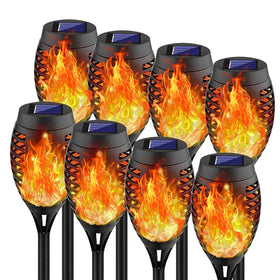Swingers solar torch lights glow along a garden path for warm, flame-free ambiance.