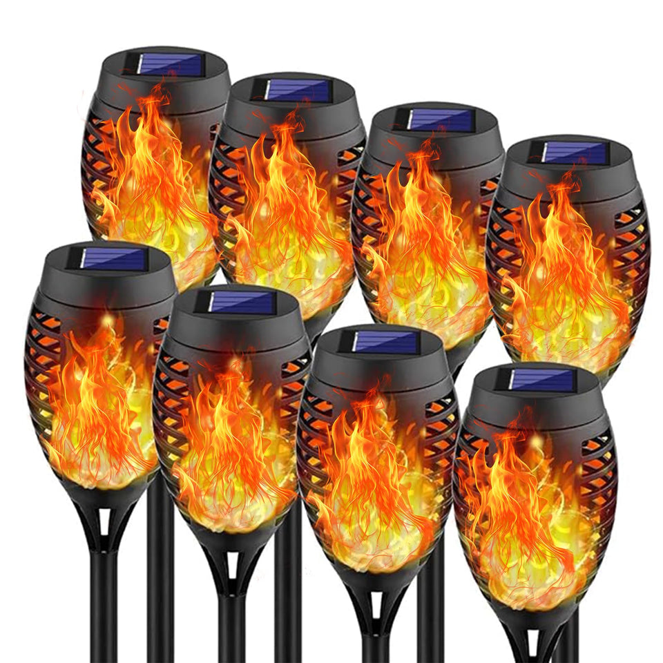 Swingers solar torch lights glow along a garden path for warm, flame-free ambiance.