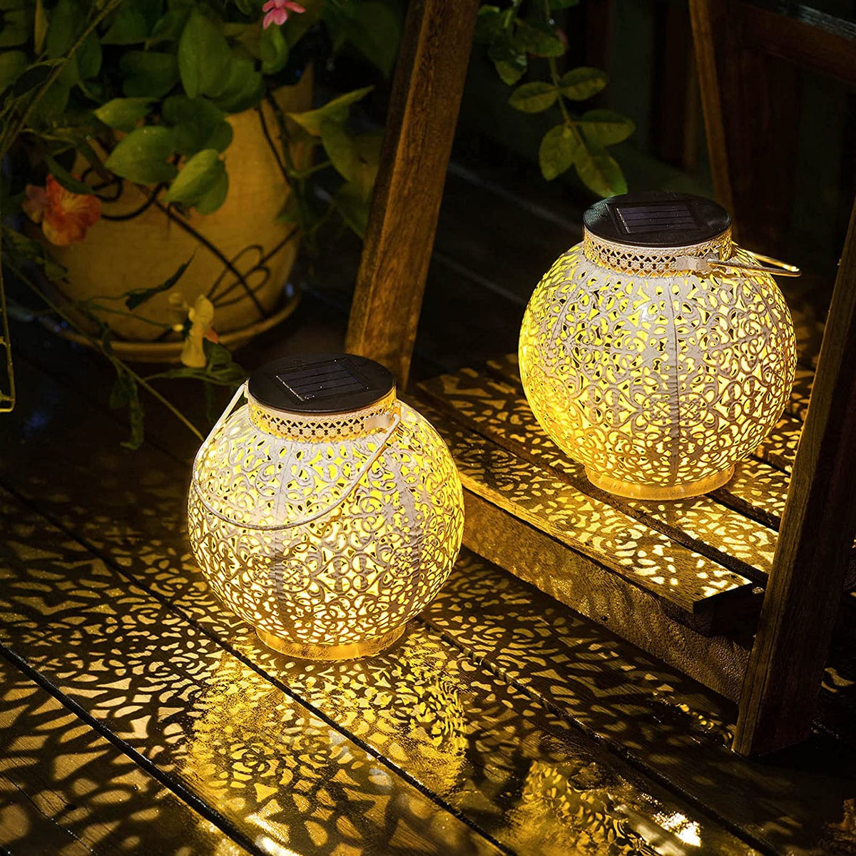TAKE ME 2-pack white solar lanterns illuminate an outdoor garden scene.