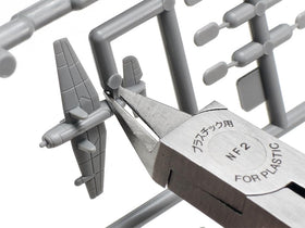 Tamiya side cutter shown slicing away small plastic components with control.