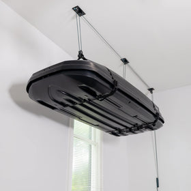 Teal Triangle ceiling storage hoist lifting a cargo box to free garage floor space.