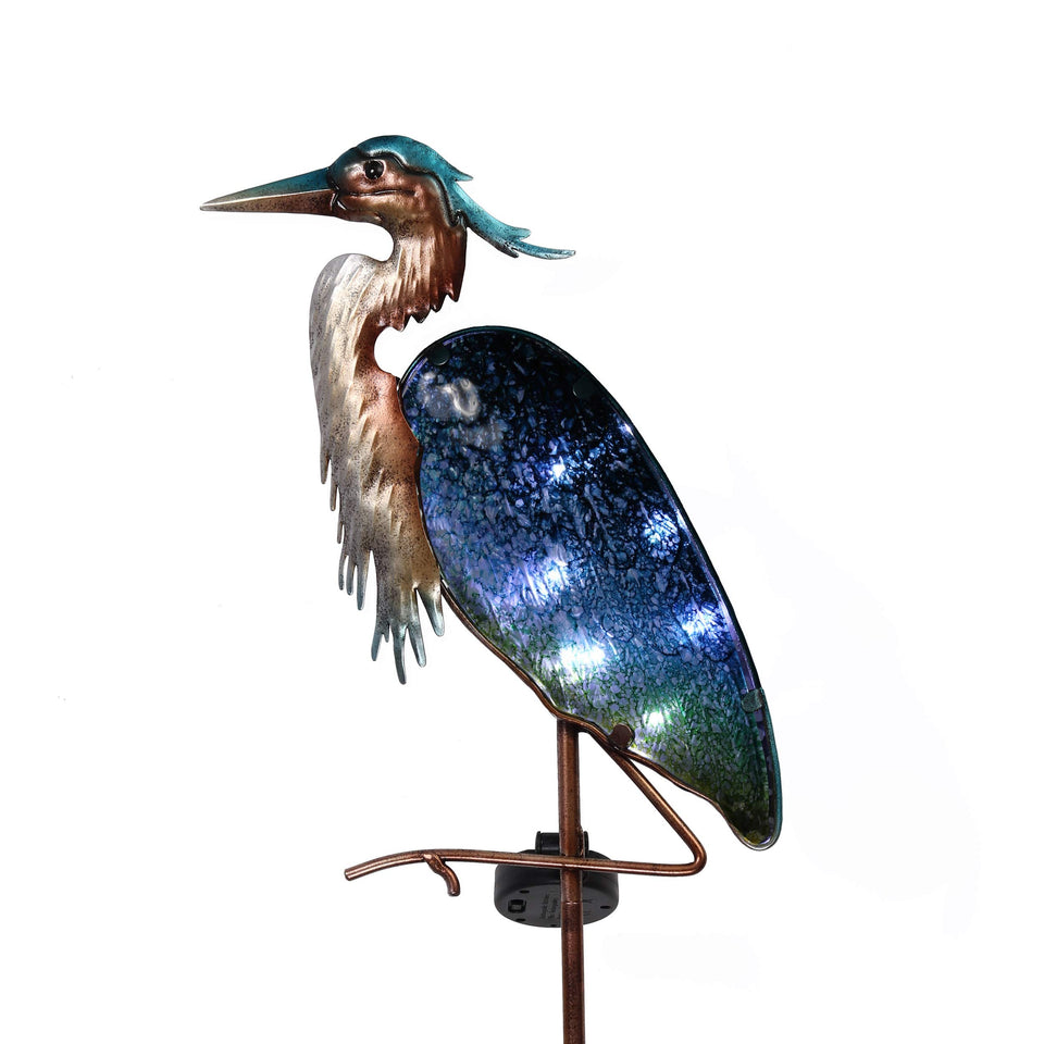 Teresa's Collections blue heron stake outdoors with illuminated glass feathers enhancing nighttime curb appeal.