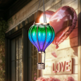 Teresa's Collections hot air balloon solar lantern hanging in yard adds festive lighting.
