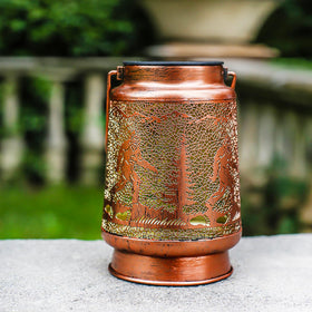 TIGGSY Bronze-textured lantern creates cozy backyard ambiance.