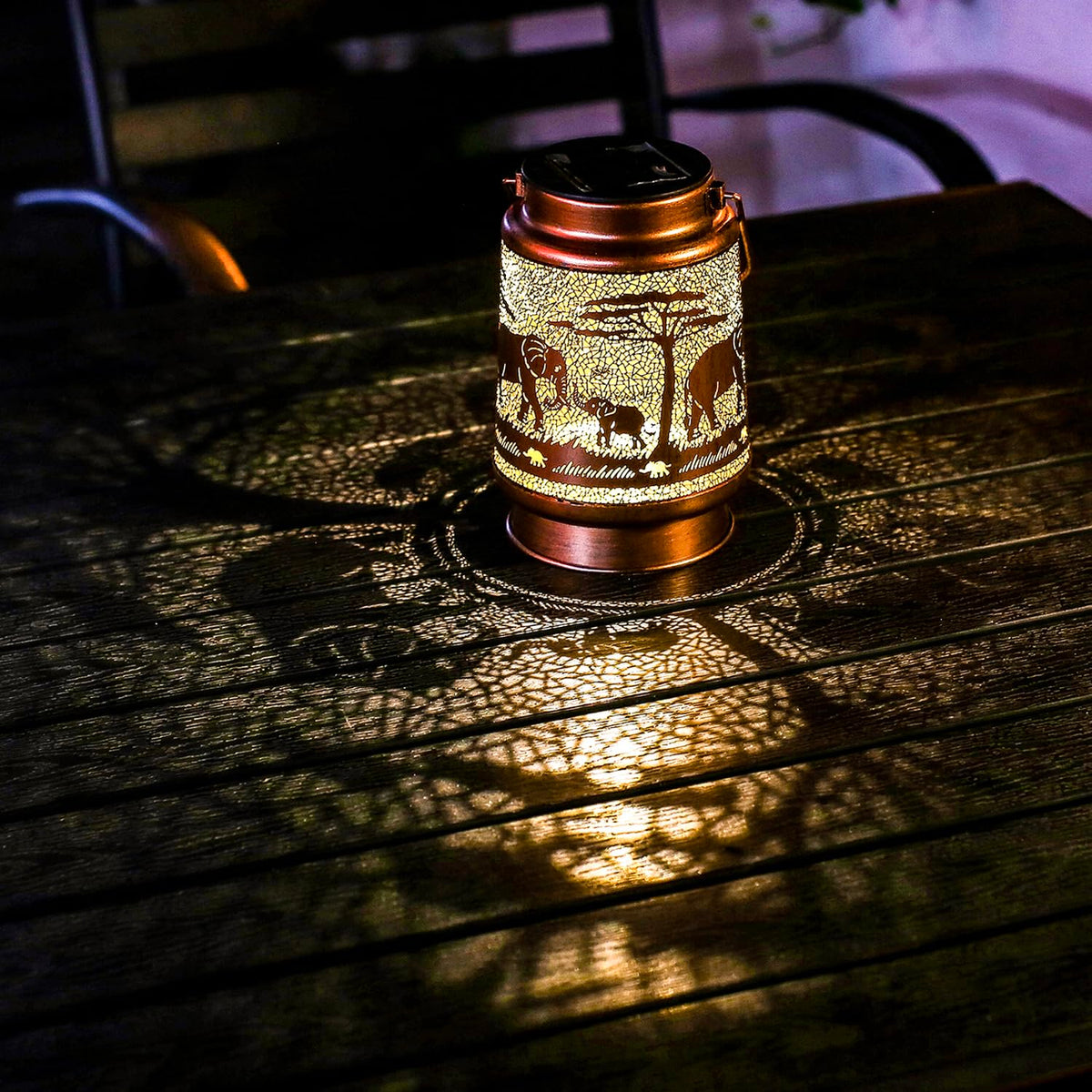 TIGGSY Elephant solar lantern emits warm glow at dusk.