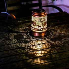 TIGGSY Elephant solar lantern emits warm glow at dusk.
