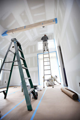 Wide X-Paper roll laid out under ladders for sturdy protection.