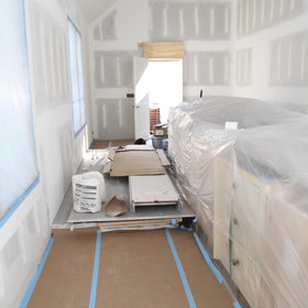 X-Paper unrolled across a wood floor for durable coverage.