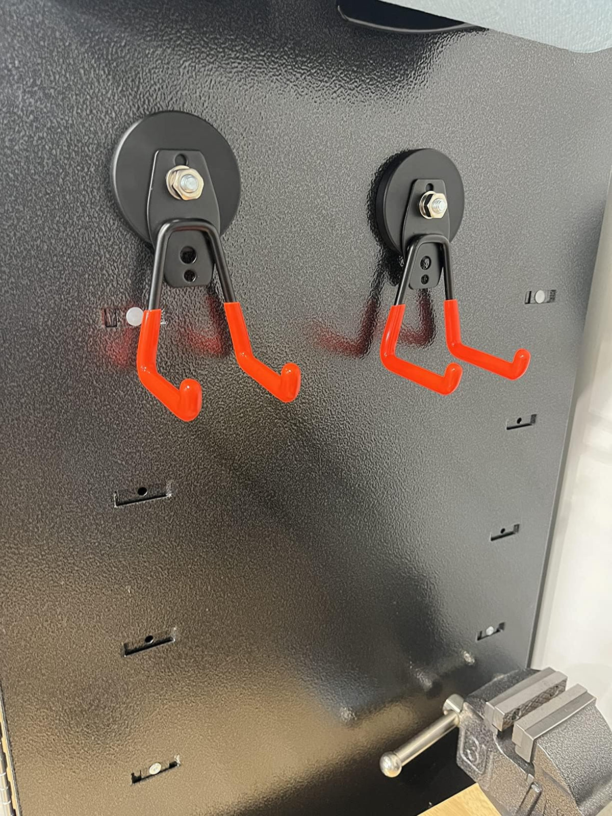Clutter-free garage with organized tools and hoses using magnetic hooks.