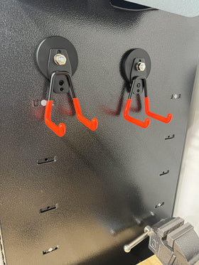 Clutter-free garage with organized tools and hoses using magnetic hooks.