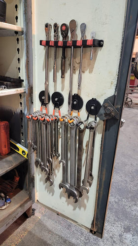 Orange ULIBERMAGNET hook in a workshop highlighting durable storage.