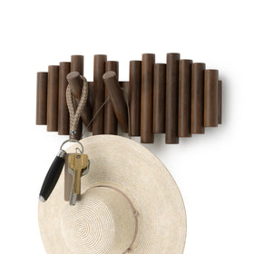 Umbra Picket wall-mount coat rack displays five fold-down wood pegs for organized storage.