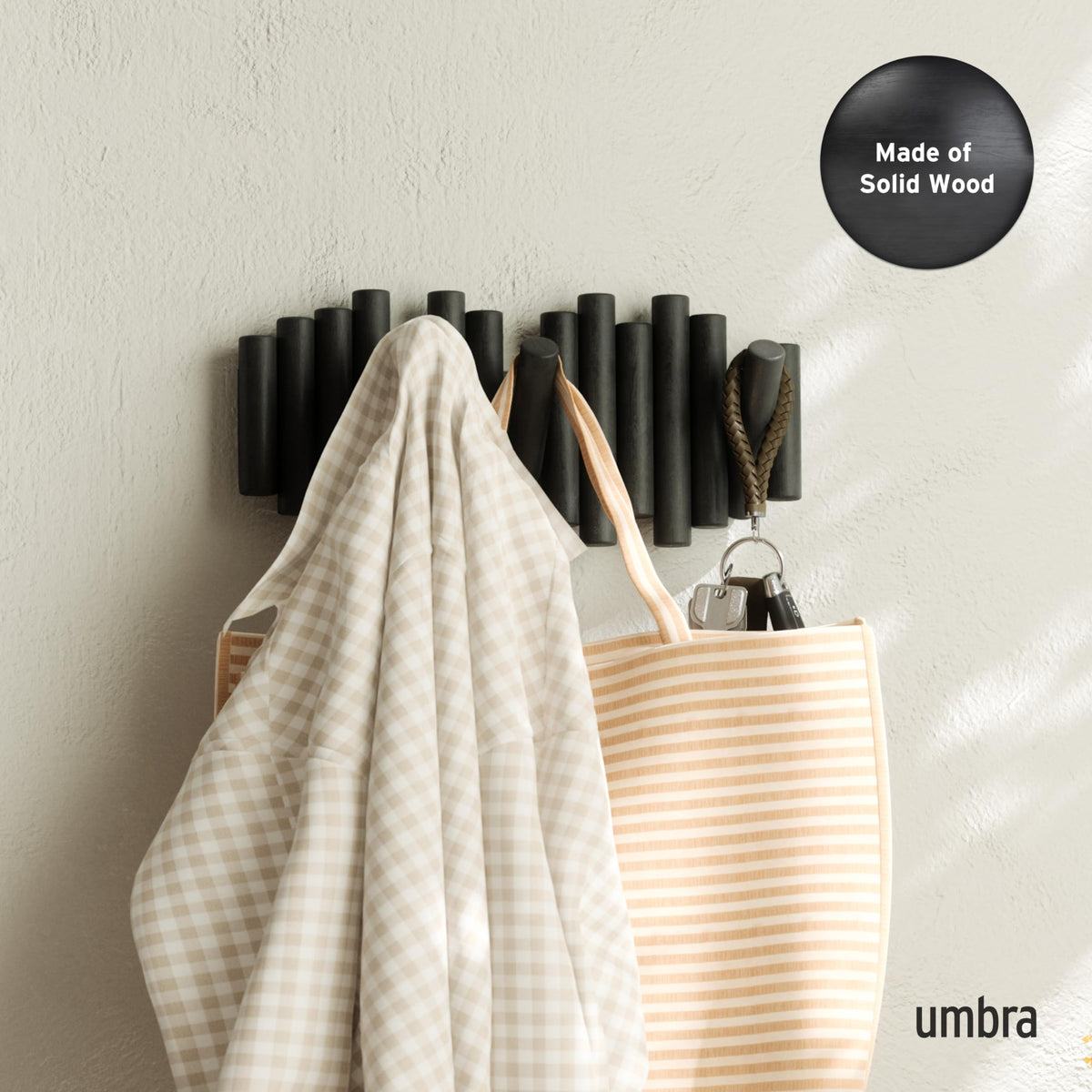 Umbra Picket wood peg fold-down design saves space when coats are not in use.