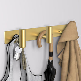 VAEHOLD gold T-shape wall mount in bathroom setting with towels