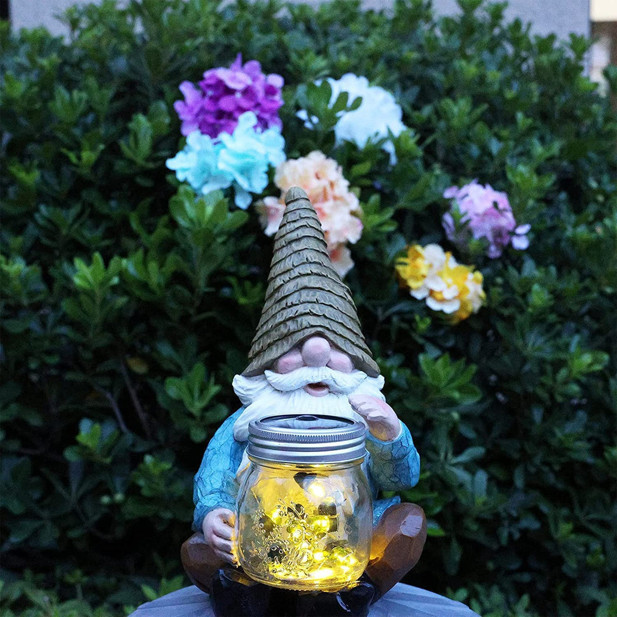Vcdsoy Large garden gnome statue anchors pathways and flower beds.