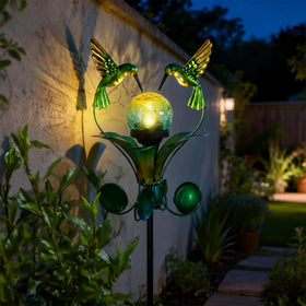 VCUTEKA solar garden stake bluebird globe lights at dusk along a garden path.