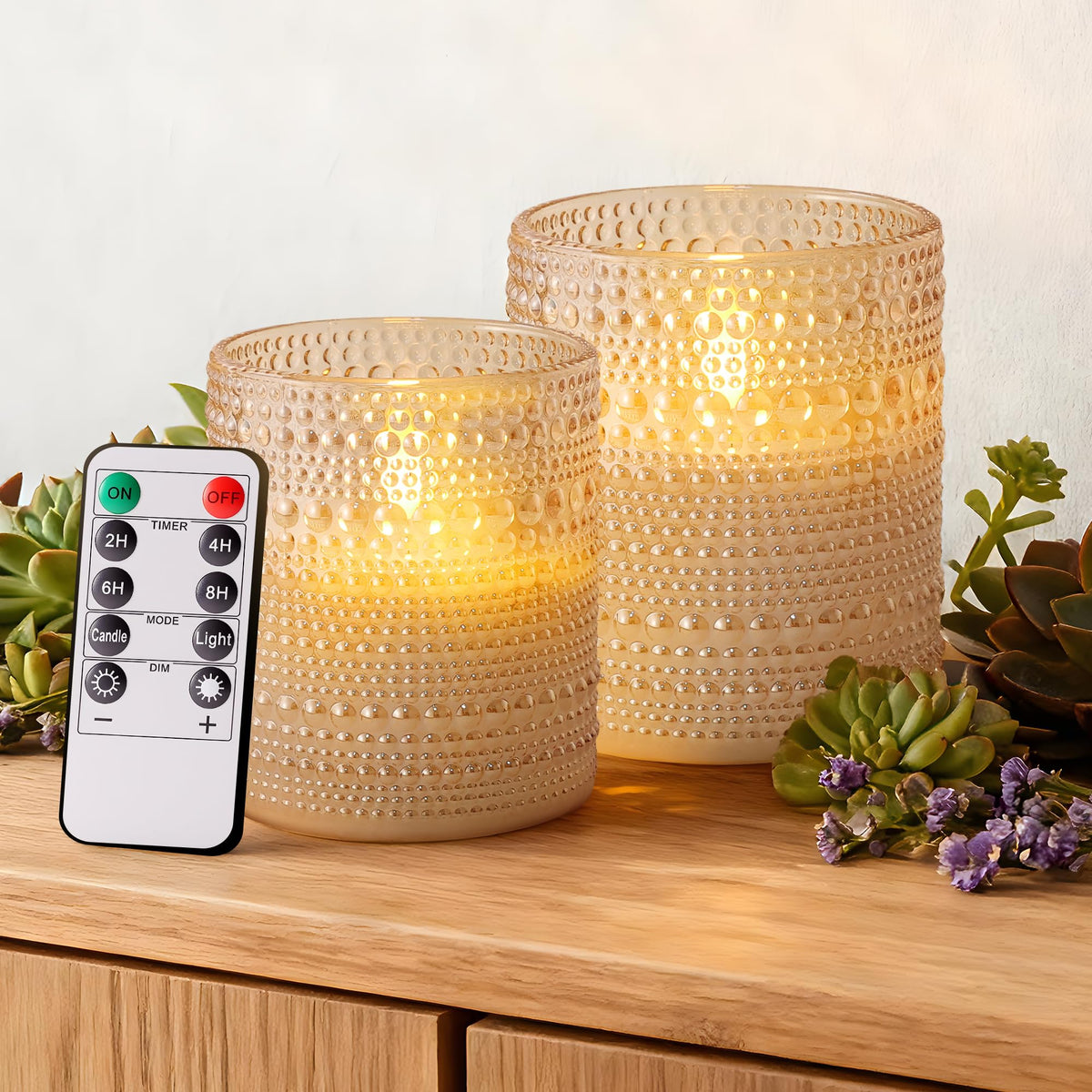 Velsyn dotted glass flameless candles with remote timer illuminate an elegant table setting.