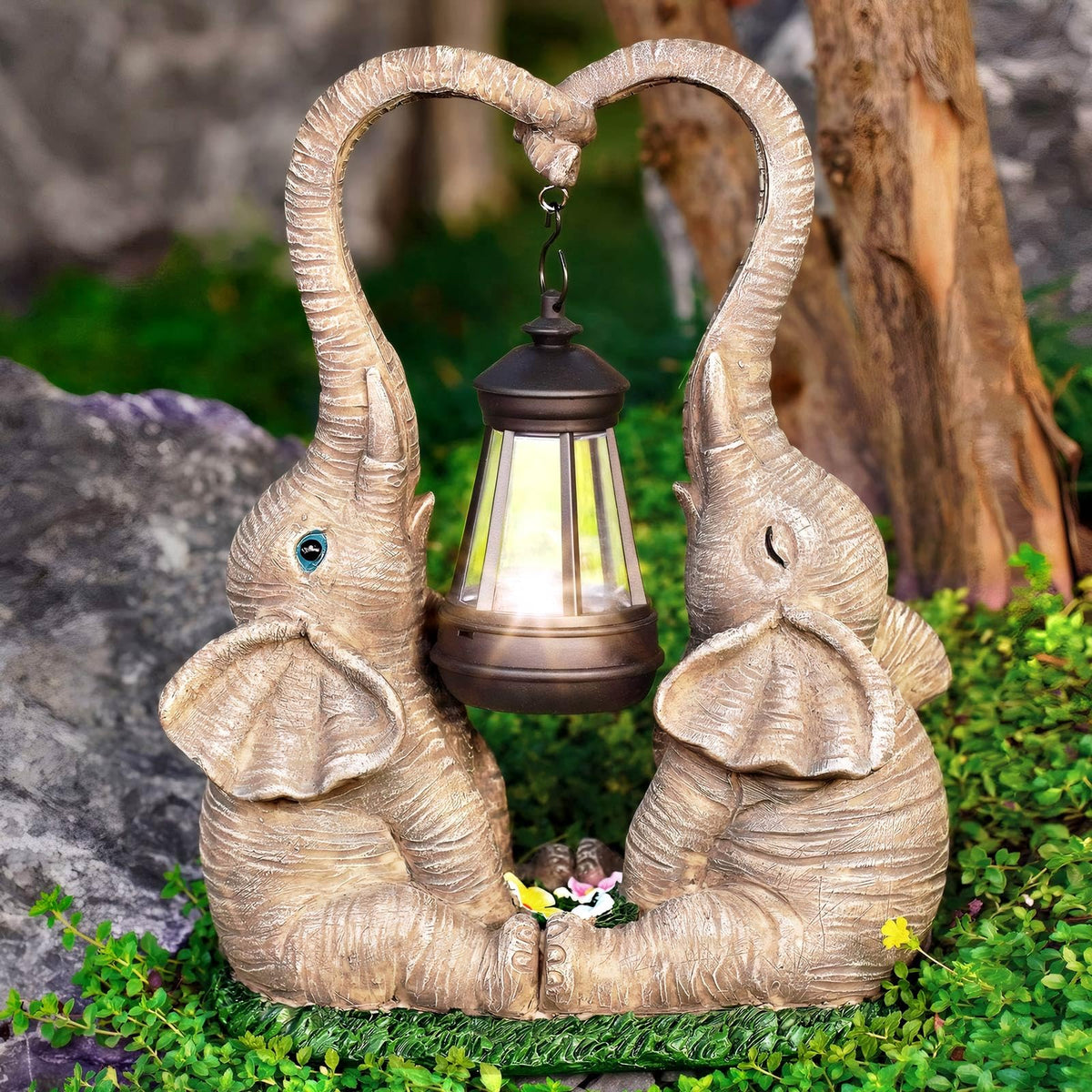 Vereemy solar-powered LED lights illuminate the garden elephant statues at night.