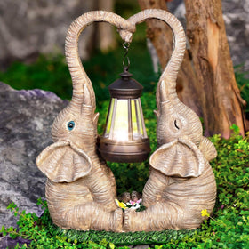 Vereemy solar-powered LED lights illuminate the garden elephant statues at night.