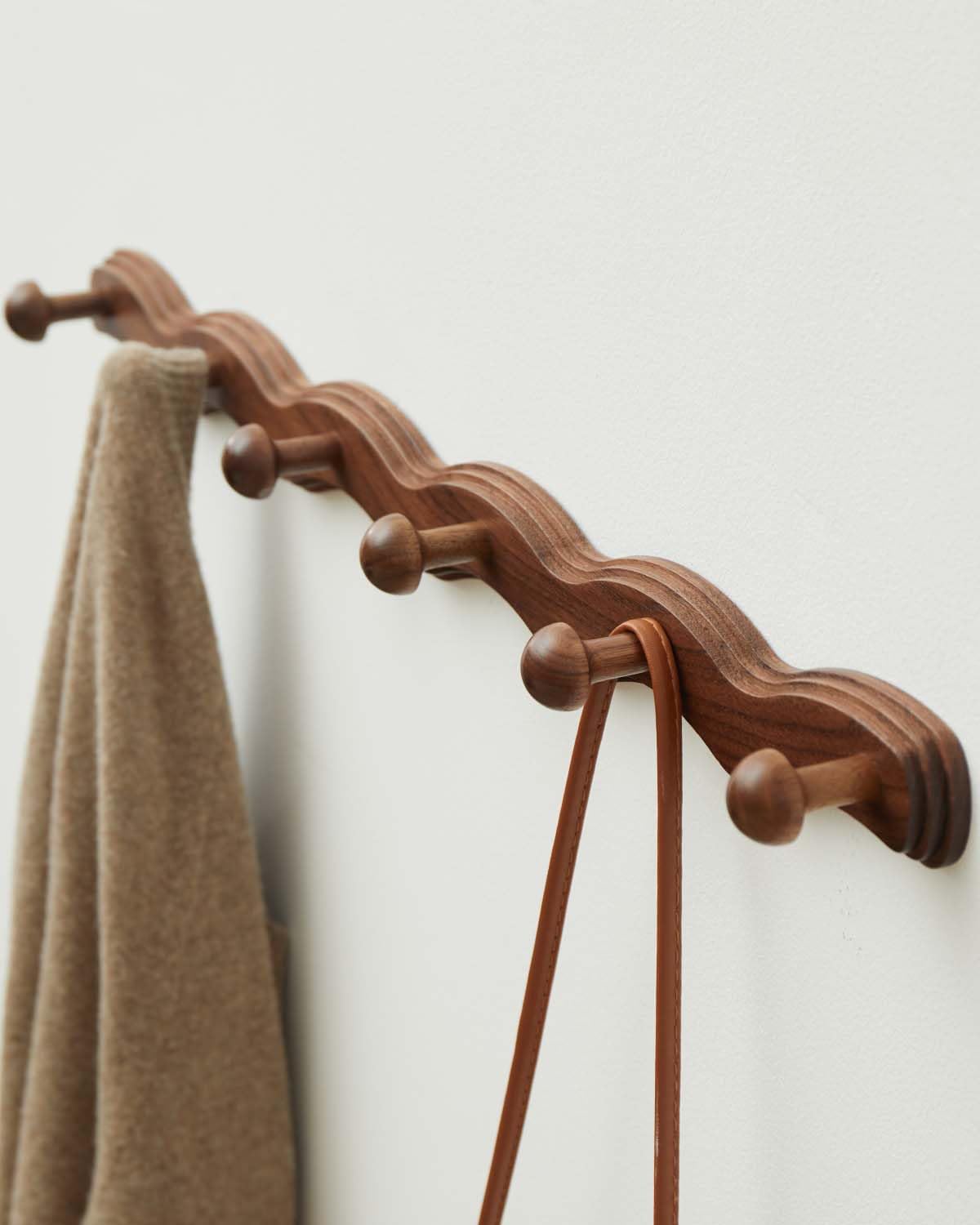 Close-up of Vinoil walnut coat rack highlighting rounded hook edges.