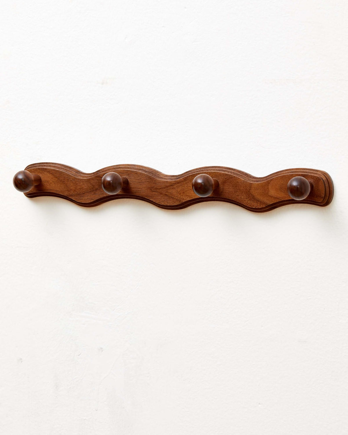 Vinoil walnut wall-mount coat rack with four hooks keeps coats and bags organized.