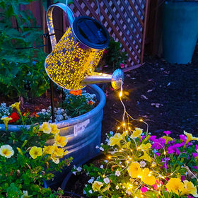 VOOKRY solar watering can lights hanging above garden path, creating ambiance.