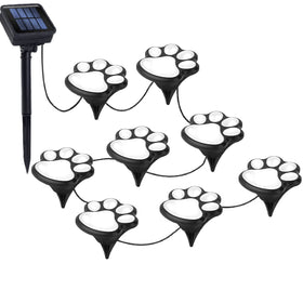 Wominoy paw print solar lights illuminate a garden path at night.