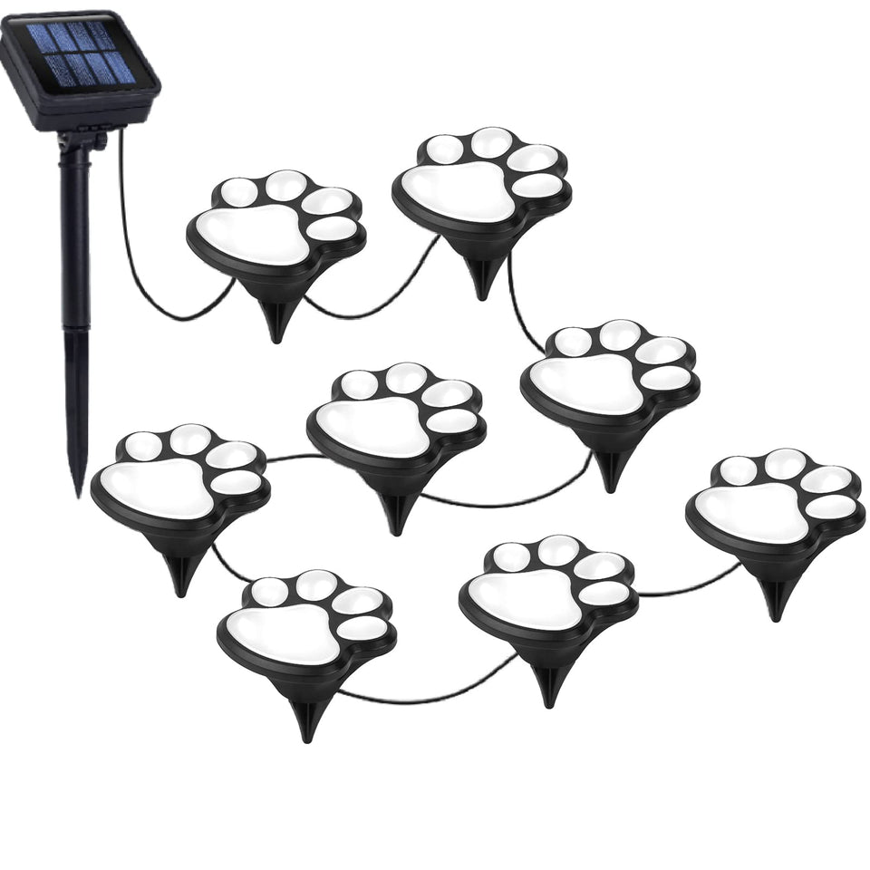 Wominoy paw print solar lights illuminate a garden path at night.