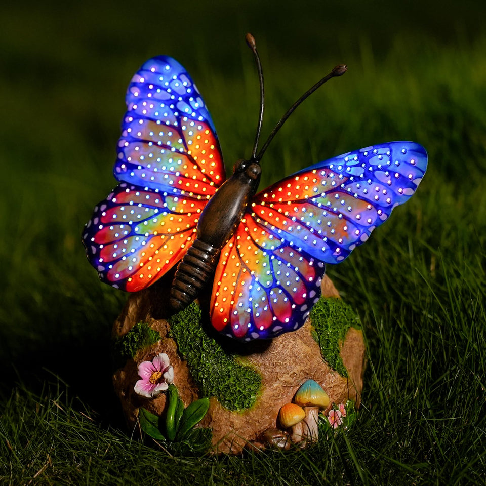WSgift solar butterfly garden statue resting among flowers in the yard.