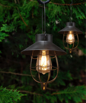 YAKii 2-pack solar lanterns hang on a black hook, creating inviting front-yard ambience.
