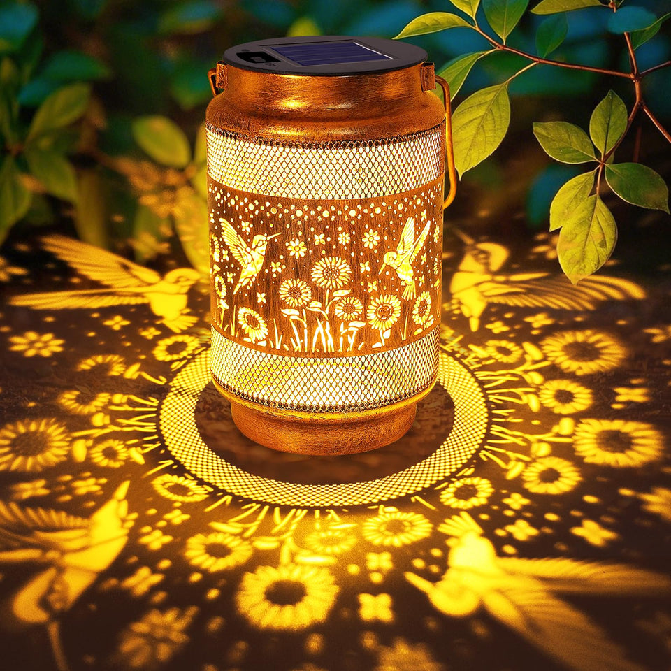 Yulloyello hummingbird solar lantern in gold bronze casts warm garden ambiance.
